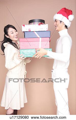 Man handing a lot of gift to woman View Large Photo Image Stock Image - Man handing a lot of gift to woman. Fotosearch
