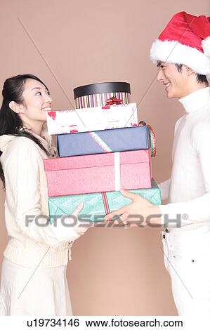 Stock Photograph - Man handing a lot of gift to woman. Fotosearch