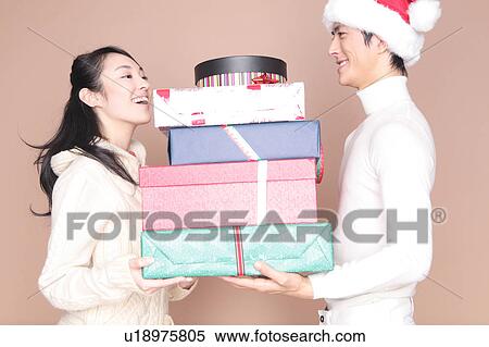 Stock Photography - Man handing a lot of gift to woman. Fotosearch