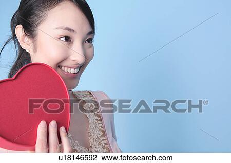 Stock Image - Woman having heart shaped box. Fotosearch