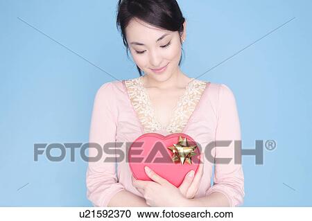 Woman holding heart shaped box View Large Photo Image Stock Image - Woman holding heart shaped box. Fotosearch