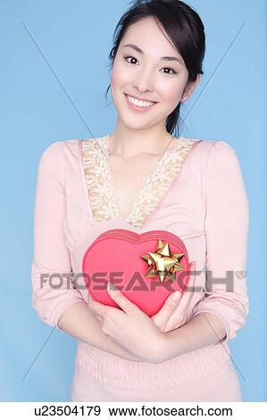 Stock Photo - Woman holding heart shaped box. Fotosearch