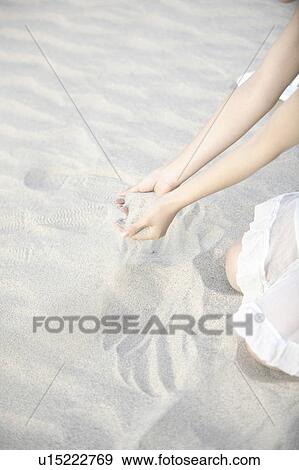 Hand of woman scooping the sand of the sandy beach View Large Photo Image Stock Photo - Hand of woman scooping the sand of the sandy beach. Fotosearch