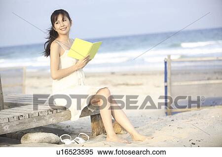 Japanese woman reading a book on a beach View Large Photo Image Stock Photography - Japanese woman reading a book on a beach. Fotosearch