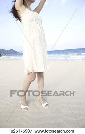Stock Photo - Japanese woman stretching on a beach. Fotosearch