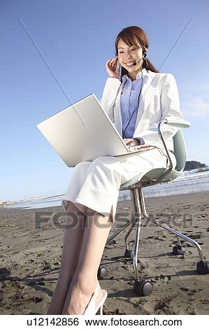 Office lady operating a PC on a beach View Large Photo Image Stock Photograph - Office lady operating a PC on a beach. Fotosearch