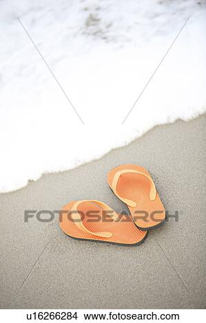 Picture - Sandals left on sandy beach. Fotosearch