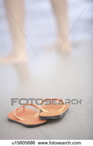 Stock Photograph - Sandals left on sandy beach. Fotosearch