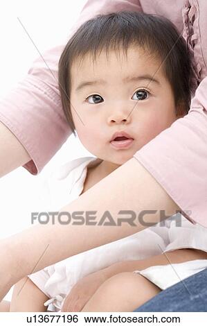 Baby sitting on her mother's lap View Large Photo Image Stock Photograph - Baby sitting on her mother's lap. Fotosearch