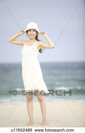 Japanese woman putting on a hat View Large Photo Image Stock Photo - Japanese woman putting on a hat. Fotosearch