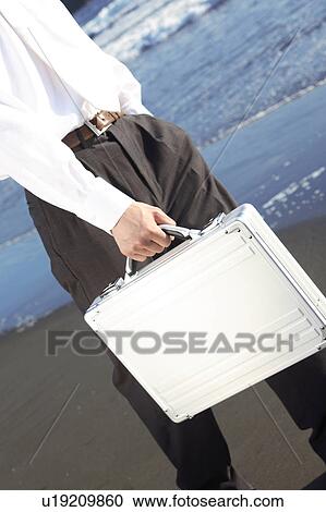 Office worker walking along beach View Large Photo Image Stock Image - Office worker walking along beach. Fotosearch