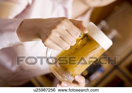 Stock Photograph - Hand having a beer mug. Fotosearch
