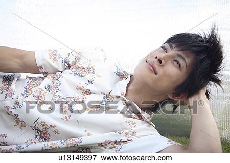 Japanese man lying down on the grass View Large Photo Image Stock Photo - Japanese man lying down on the grass. Fotosearch