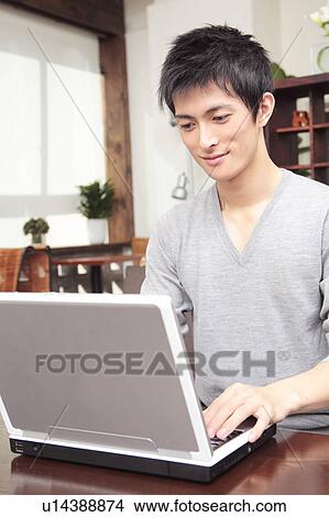 Japanese man operating a PC View Large Photo Image Picture - Japanese man operating a PC. Fotosearch