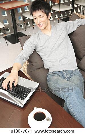 Stock Image - Japanese man operating a PC. Fotosearch