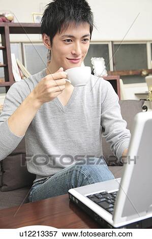 Stock Photo - Japanese man operating a PC. Fotosearch