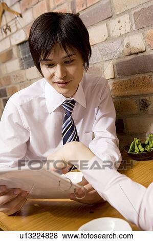 Stock Photo - Office worker choosing meal from the menu. Fotosearch