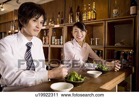 Stock Image - Office workers waiting for service at bar. Fotosearch