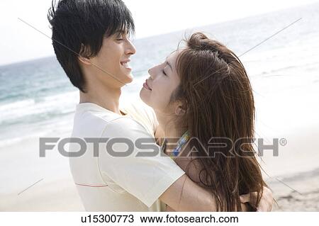 Stock Image - Couple hugging each other on a beach. Fotosearch