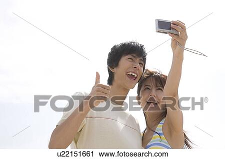 Stock Image - Japanese couple shooting photo. Fotosearch