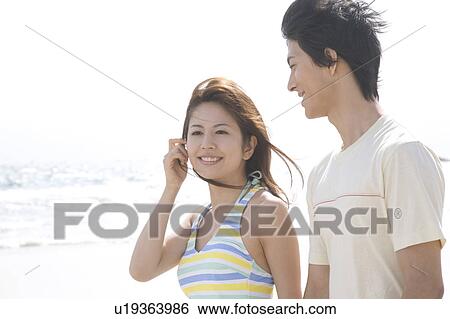 Japanese couple walking on a beach View Large Photo Image Stock Photograph - Japanese couple walking on a beach. Fotosearch