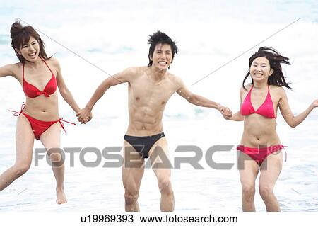Stock Image - Japanese in swimsuit playing in a beach. Fotosearch