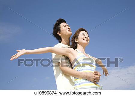 Picture - Japanese man embracing his lover from back. Fotosearch