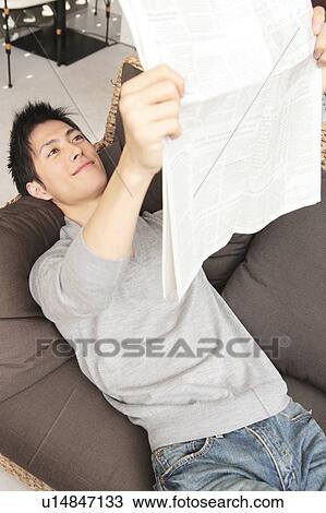 Stock Image - Japanese man reading a newspaper. Fotosearch