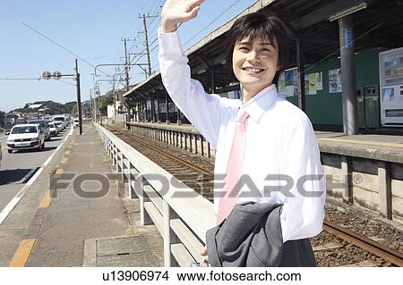 Picture - Japanese office worker raising hand. Fotosearch
