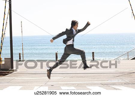 Stock Photography - Jumping Japanese office worker. Fotosearch