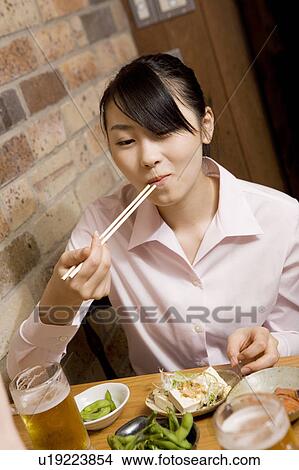 Picture - Woman having a good time at bar. Fotosearch