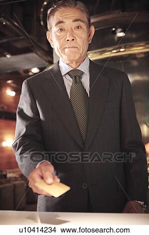 Japanese executive checking by credit card View Large Photo Image Picture - Japanese executive checking by credit card. Fotosearch