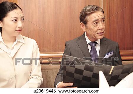 Japanese executive looking at a menu View Large Photo Image Stock Photography - Japanese executive looking at a menu. Fotosearch