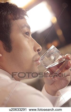 Office worker holding a whiskey glass View Large Photo Image Stock Image - Office worker holding a whiskey glass. Fotosearch