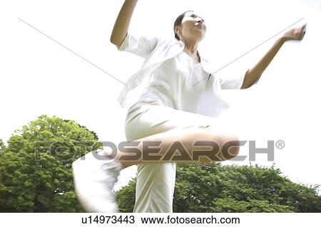 Stock Image - Japanese woman jumping. Fotosearch