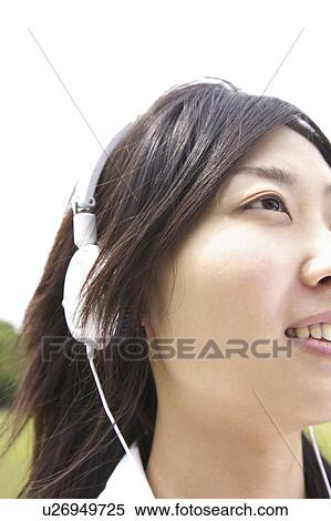 Japanese woman listening to the music in a park View Large Photo Image Stock Photography - Japanese woman listening to the music in a park. Fotosearch