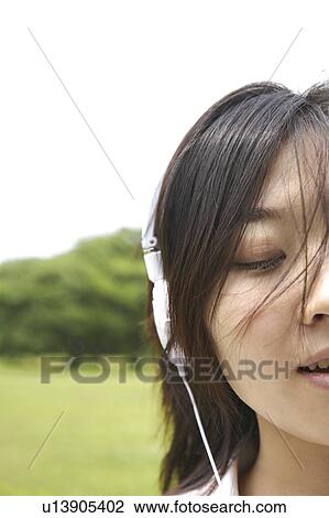 Woman listening to the music in a park View Large Photo Image Stock Image - Woman listening to the music in a park. Fotosearch