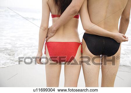 Picture - Back figure of Japanese couple in swimsuit. Fotosearch