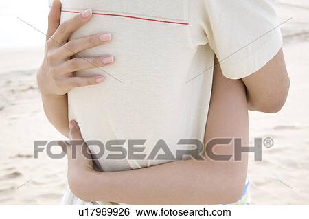 Stock Photograph - Couple hugging each other on a beach. Fotosearch