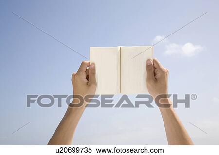 Stock Photography - Hands holding up a book. Fotosearch