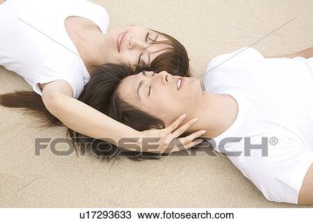 Japanese couple lying on a beach View Large Photo Image Stock Image - Japanese couple lying on a beach. Fotosearch