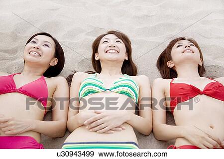 Japanese weman lying on a beach in swimsuit View Large Photo Image Stock Photo - Japanese weman lying on a beach in swimsuit. Fotosearch