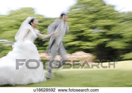 Bridal couple running in garden View Large Photo Image Stock Image - Bridal couple running in garden. Fotosearch