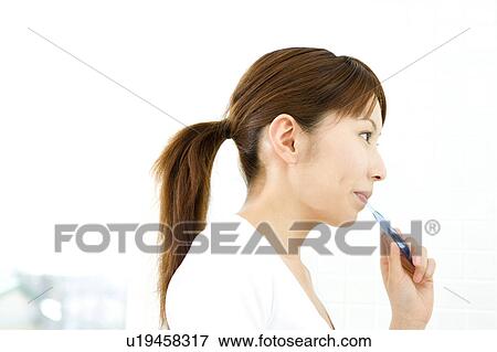 Stock Photo - Japanese woman brushing teeth. Fotosearch