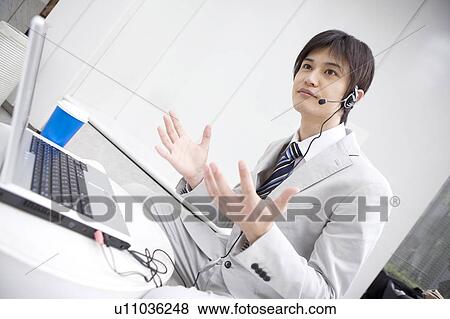 Stock Photo - Business man talking with headset. Fotosearch