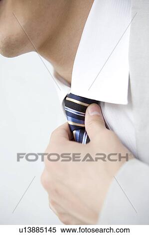 Businessman putting on a necktie View Large Photo Image Stock Photography - Businessman putting on a necktie. Fotosearch