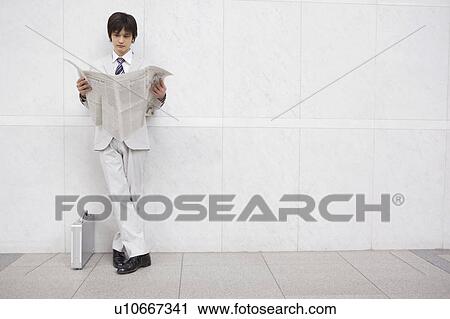 Stock Image - Businessman reading a newspaper. Fotosearch
