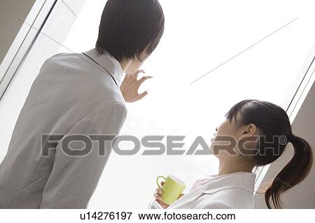 Coworkers looking out office window View Large Photo Image Stock Photo - Coworkers looking out office window. Fotosearch