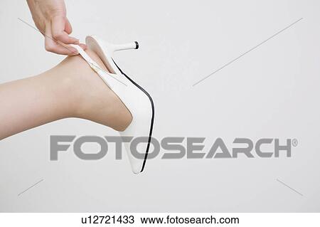 Stock Image - Foot of woman putting on a shoe. Fotosearch