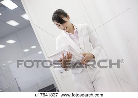 Stock Photo - Office lady holding many documents. Fotosearch